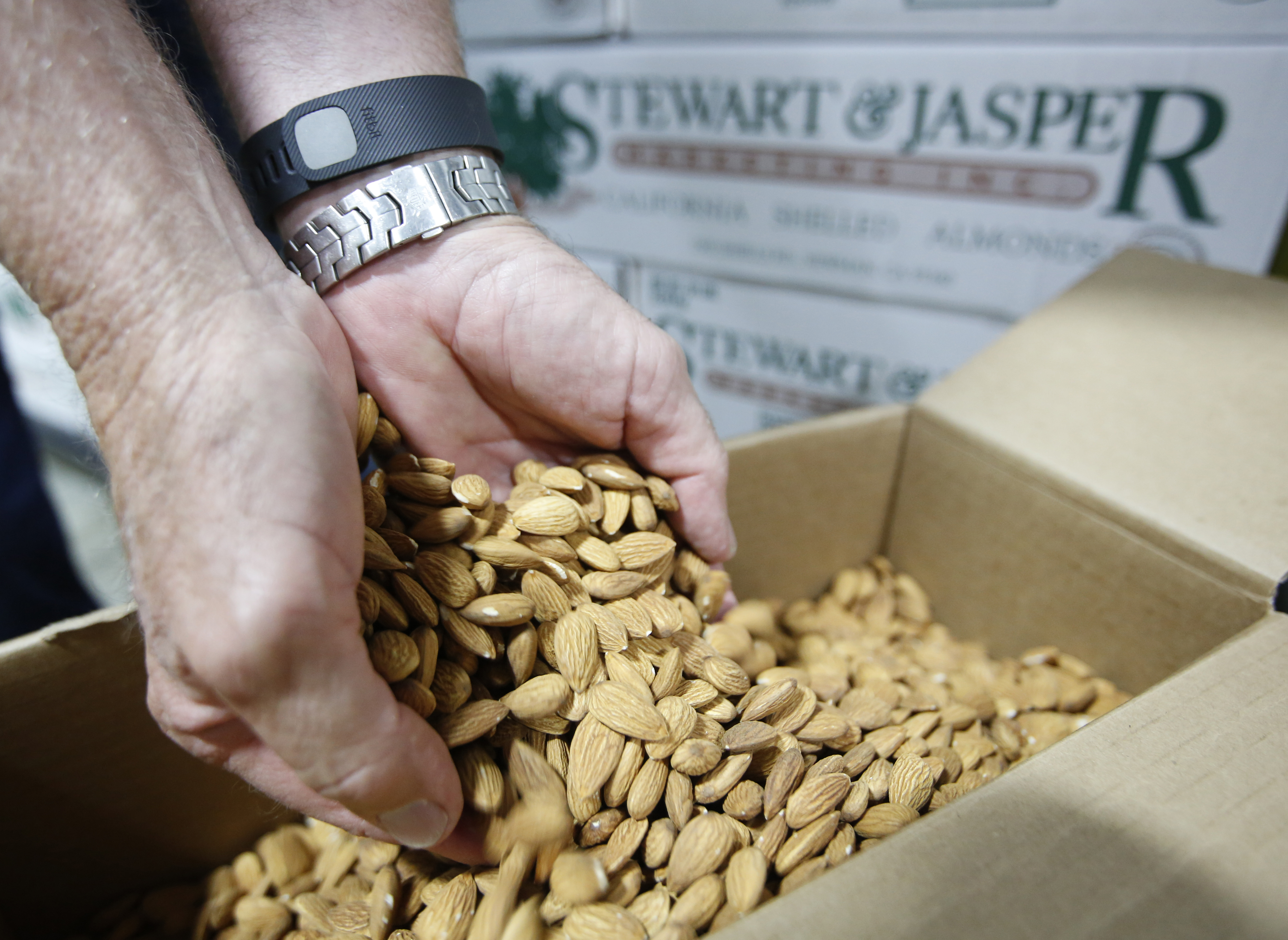 In July 2015, Jim Jasper, owner of Stewart Jasper Orchards, displays a box of almonds that are ready for shipping at his processing plant in Newman, Calif. Many Californians are just learning how much water it takes to grow their favorite foods. (Rich Pedroncelli, AP)