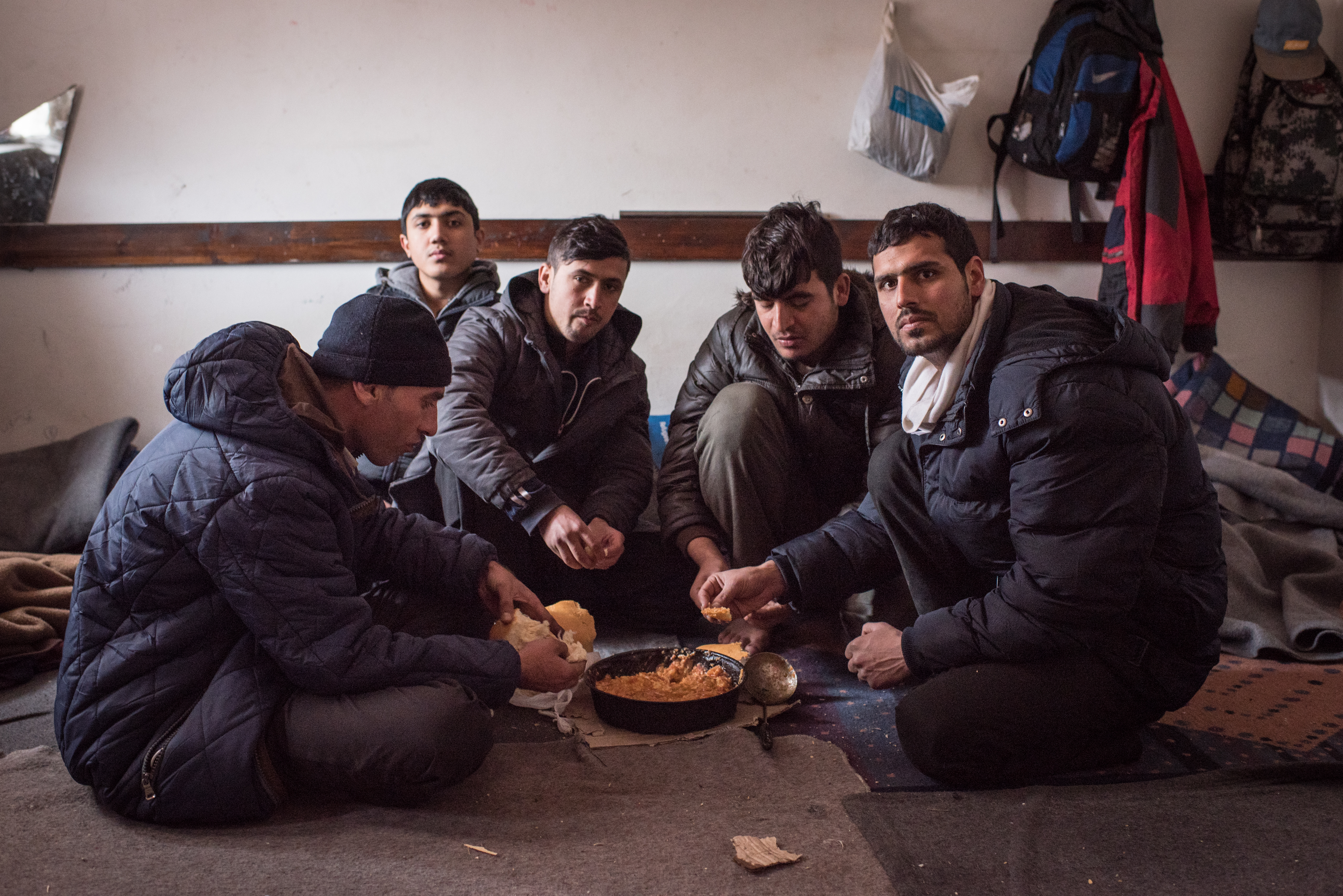 Kamal Zadran, a 20-year-old English teacher from Kabul, Afghanistan, with his four cousins inside their room in the train depot. (Diego Cupolo)