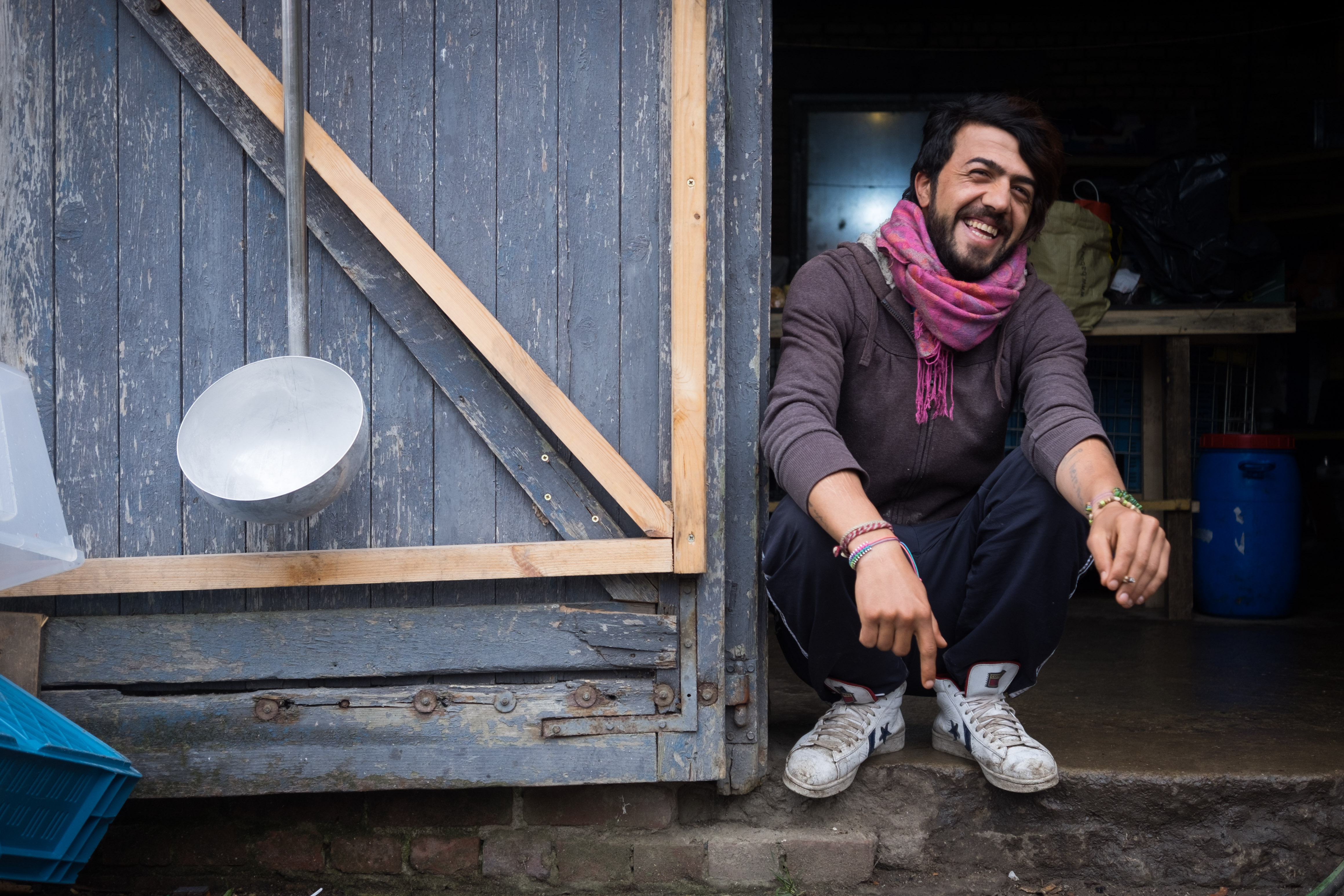 Hama Sheren, a kitchen hand and an Iraqi Kurdish refugee at Grand Synthe, jokes with his friends during a cigarette break. (Razan Alzayani)