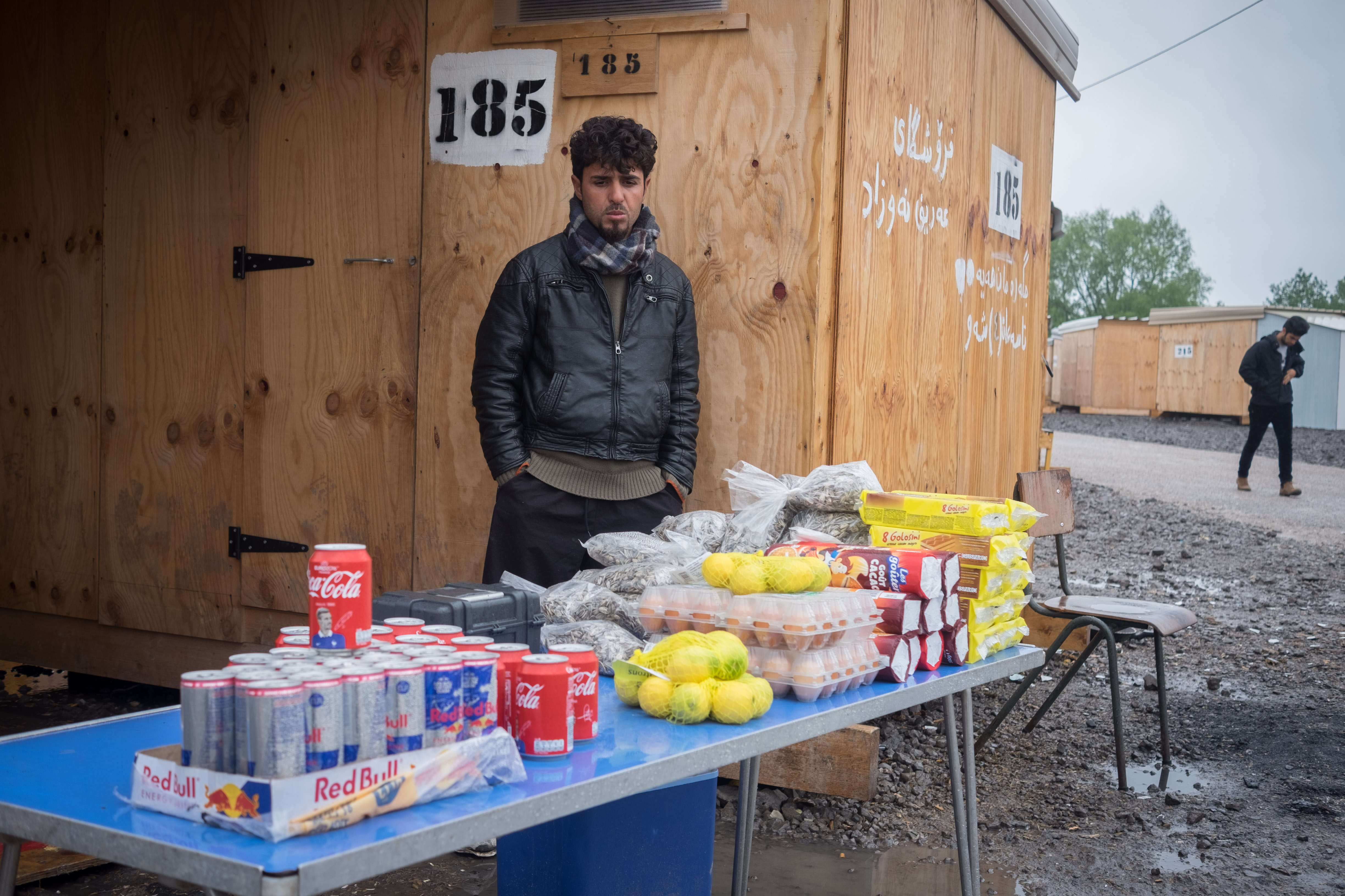 An Iranian asylum seeker poses for a portrait with his produce. (Razan Alzayani)