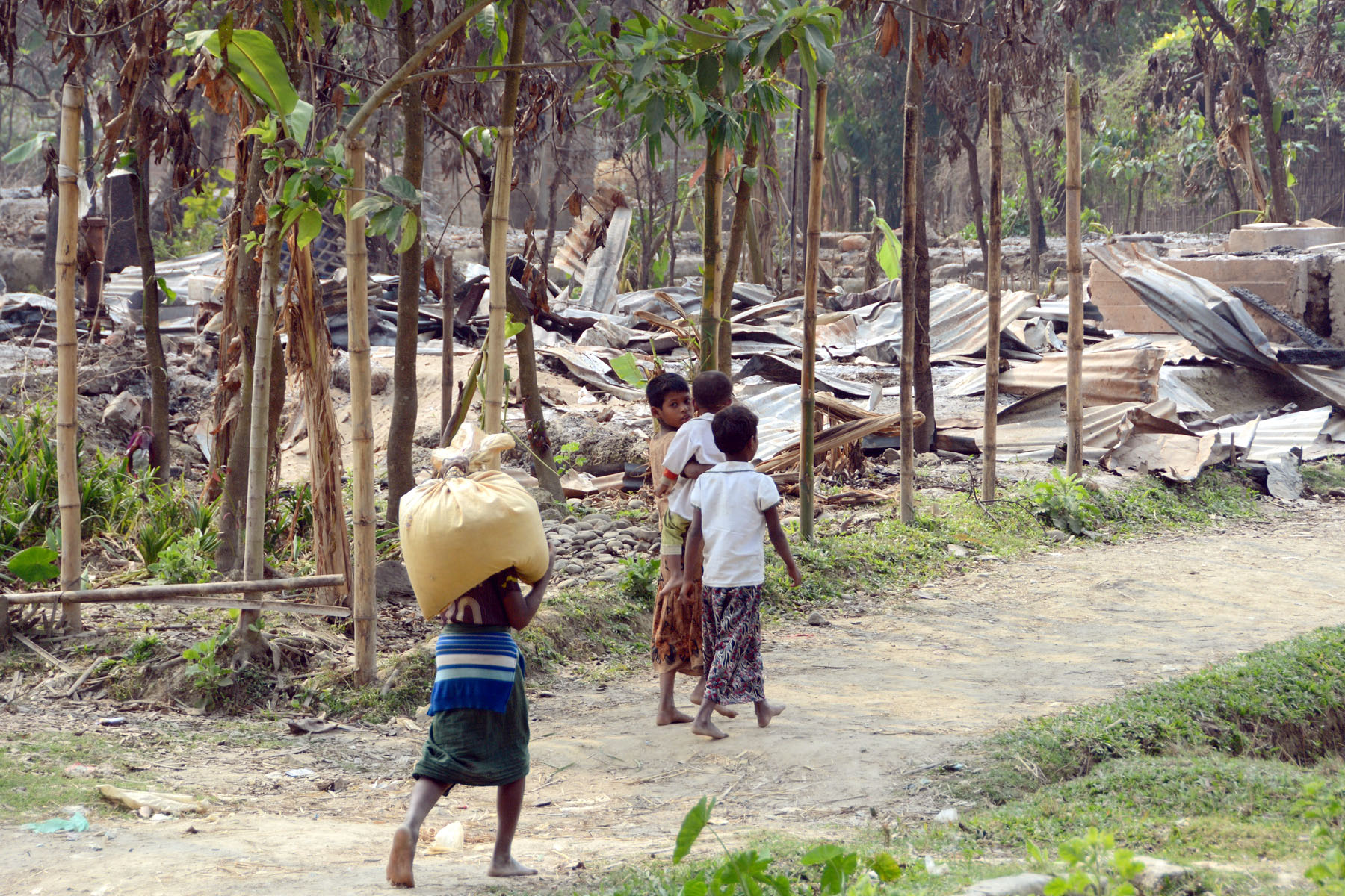 Local residents walk past burned houses in Maungdaw in Myanmar's Rakhine State, which has a large Muslim Rohingya population. They claim soldiers from the country's armed forces burned a village in October. A number of Rohingya women there also claim to have been raped. (Kyodo)