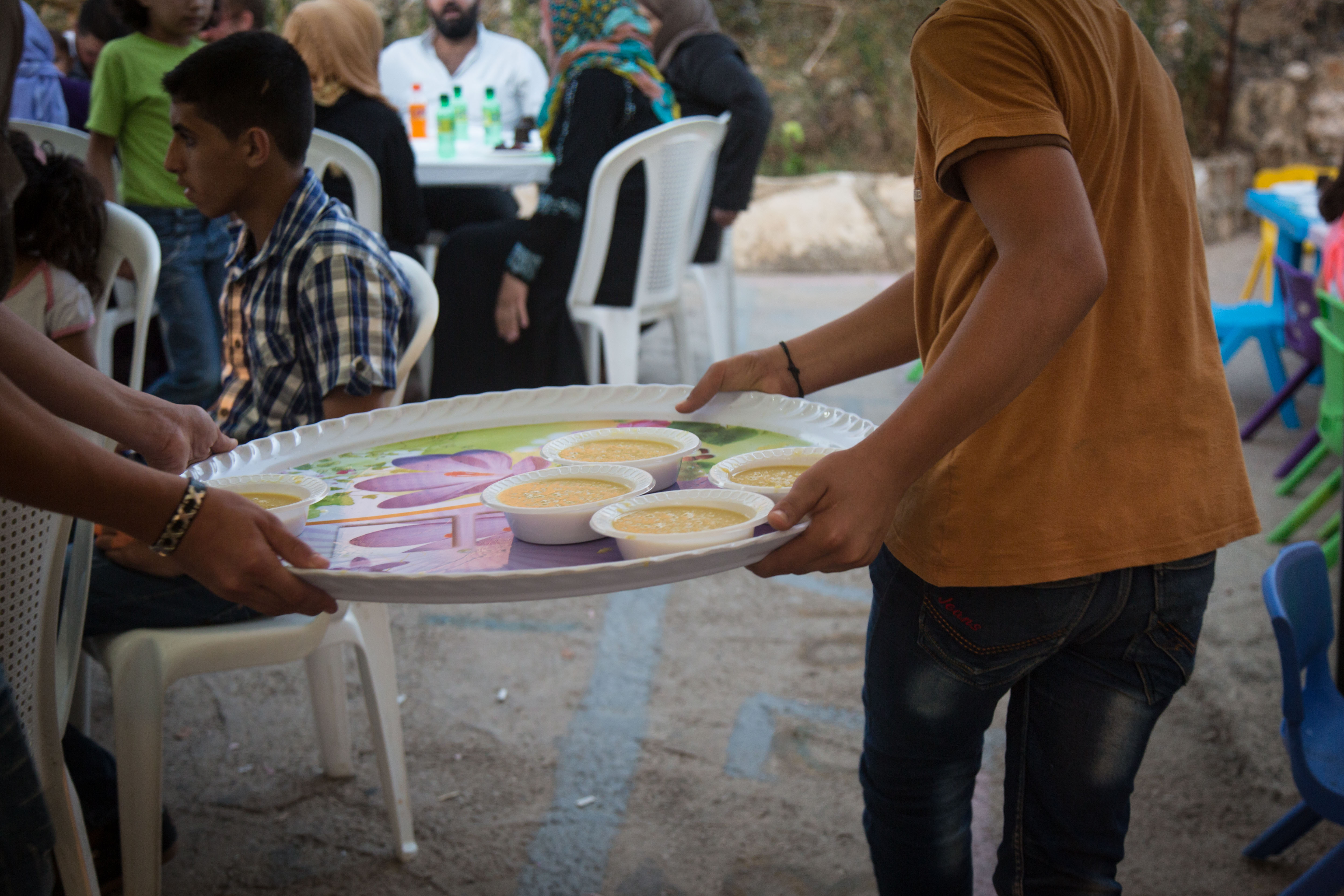 The team at the INTERSOS community center cooks a meal for team members, people from the community and young people in the empowerment program run jointly with UNFPA. “Here we have become one big family,” says Raneem. “I know most of these young people because I reach out to them to explain to them what I myself have learned.” (Sima Diab/UNFPA)