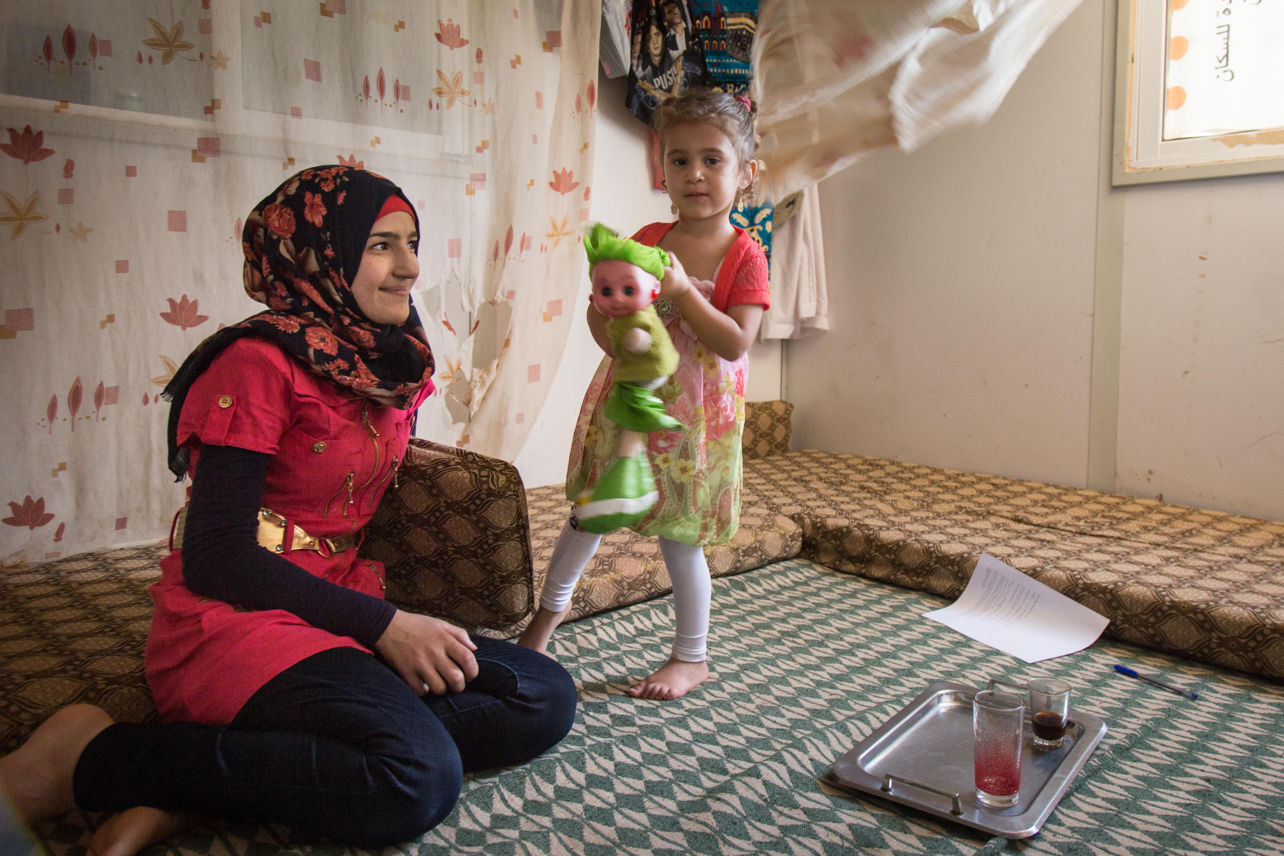 Saba, with her younger sister, says the stress and circumstances of living as refugees increases the chances of child marriage for young Syrians in the Zaatari camp. "The family has a big role in the decision, as many parents tell their children that marriage is a better destiny for them in the middle of this uncertainty we are living in," she says. (Sima Diab/UNFPA)