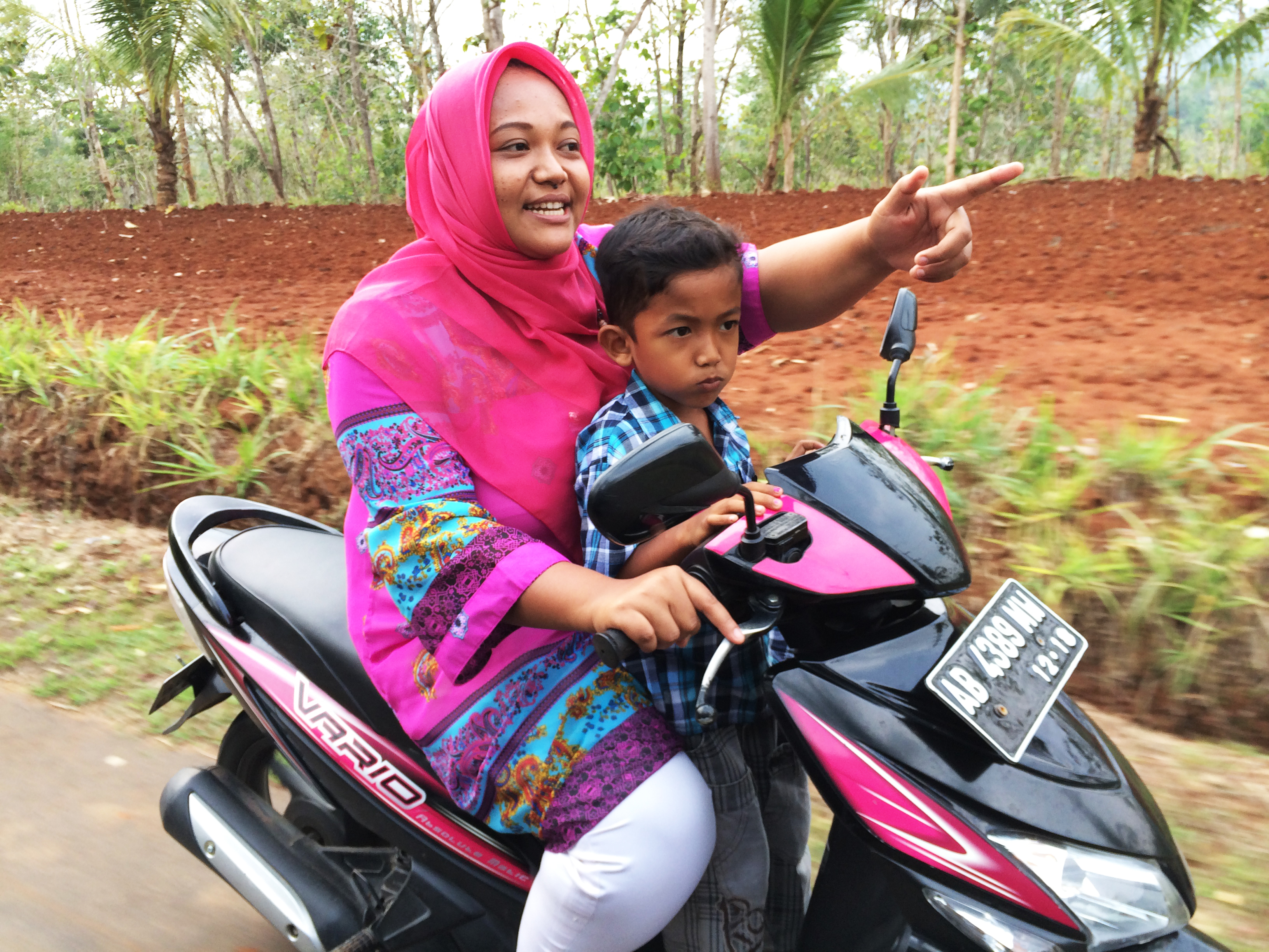 Trisuprapti rides her motorcycle with her son. She says she felt she had nowhere to turn when she got pregnant. (Sonia Narang)